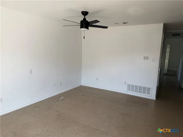 a view of a room with a ceiling fan