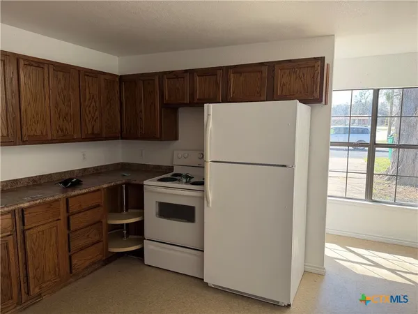 a kitchen with stainless steel appliances a refrigerator and a stove top oven