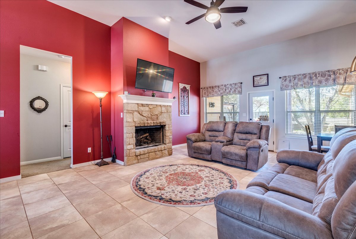 11 Rhapsody Lane Wimberley, TX 78676 - Photo 5 of 35 a living room with furniture a flat screen tv and a fireplace