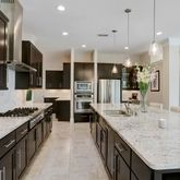 a kitchen with granite countertop kitchen island stainless steel appliances a sink stove and refrigerator