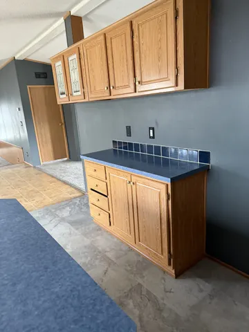 a kitchen with granite countertop a sink a stove and cabinets