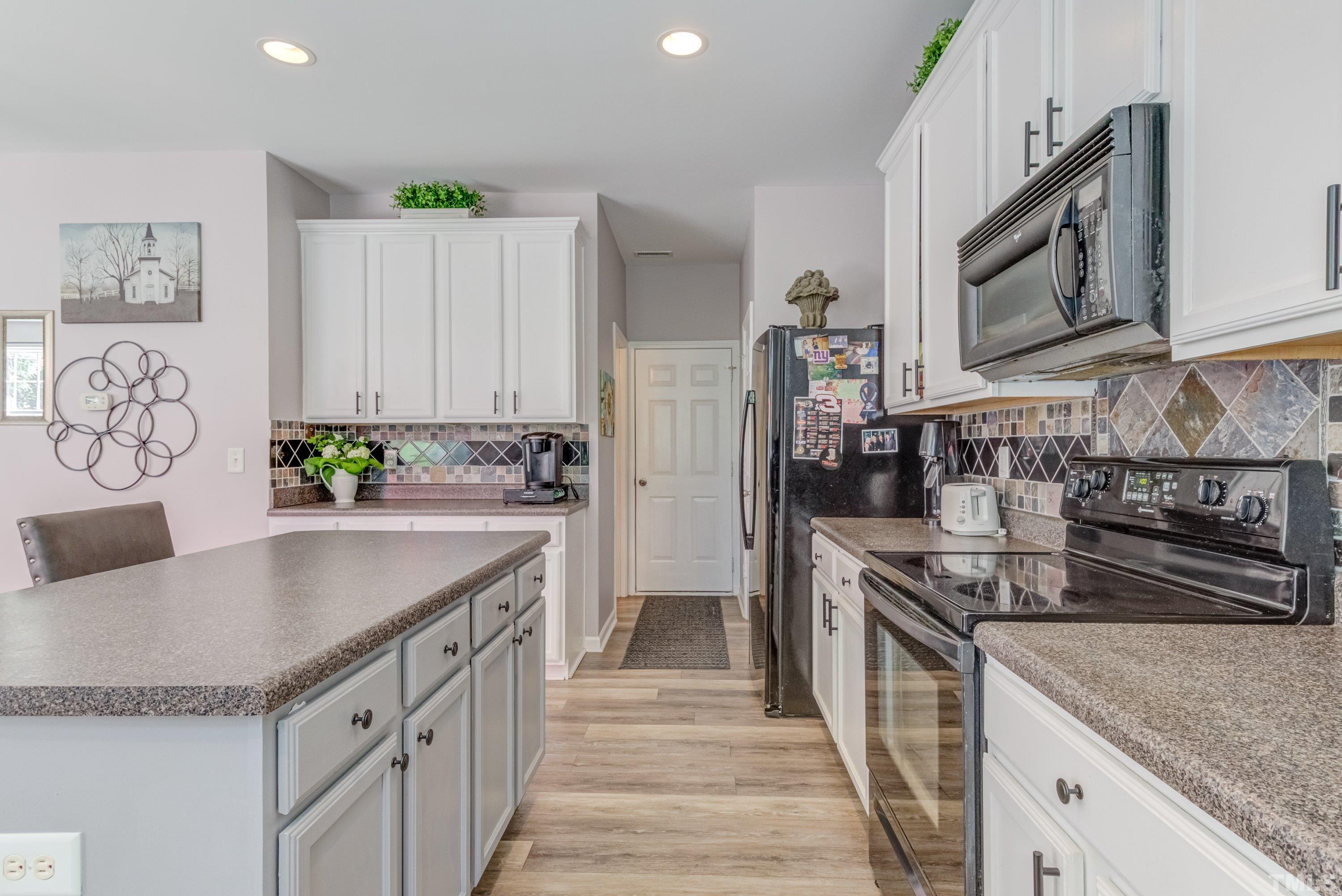 121 Ryder Cup Circle Raleigh, NC 27603 - Photo 18 of 43 a kitchen with stainless steel appliances granite countertop a sink stove and refrigerator