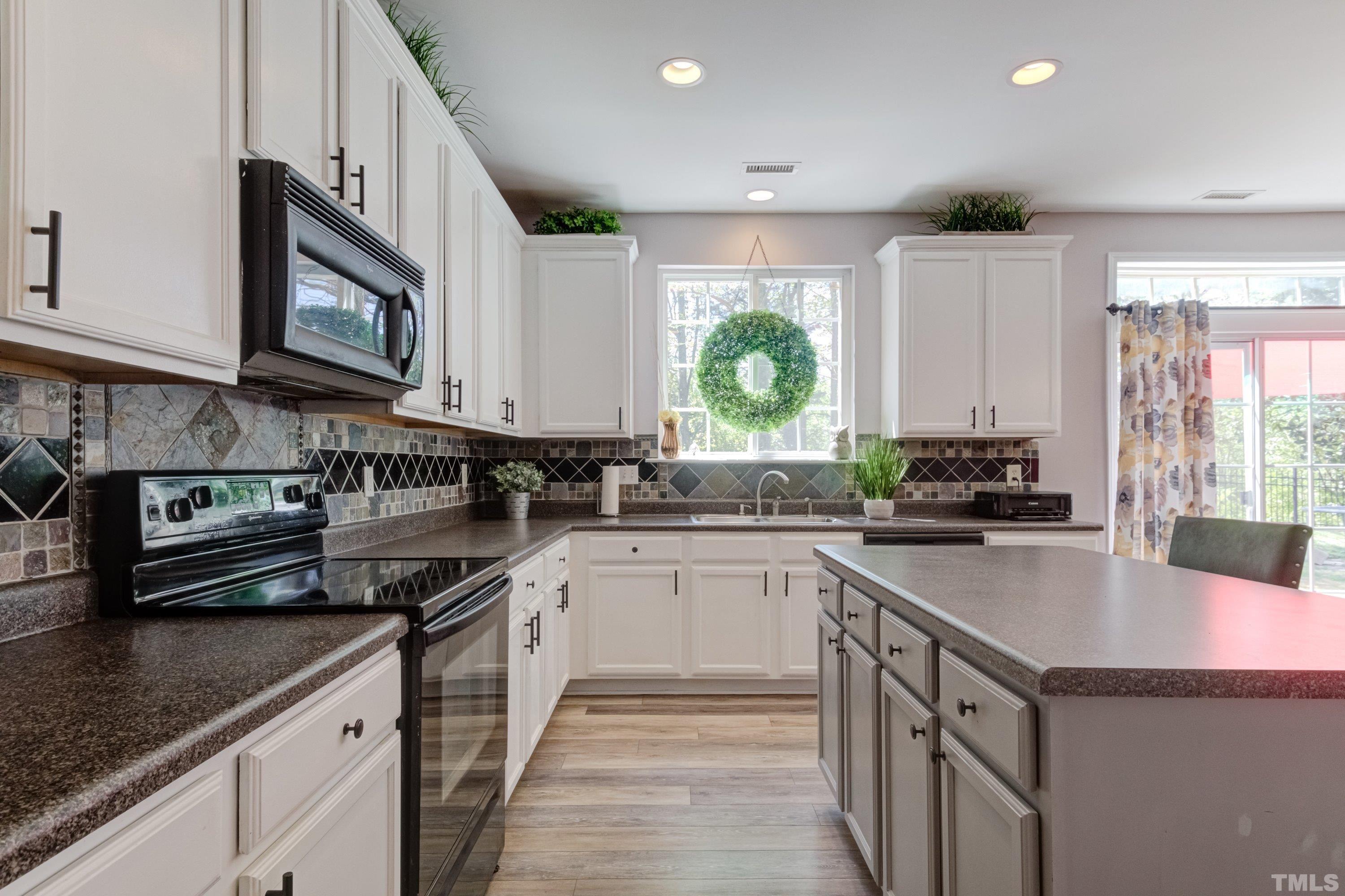 121 Ryder Cup Circle Raleigh, NC 27603 - Photo 19 of 43 a kitchen with stainless steel appliances granite countertop a sink stove and cabinets