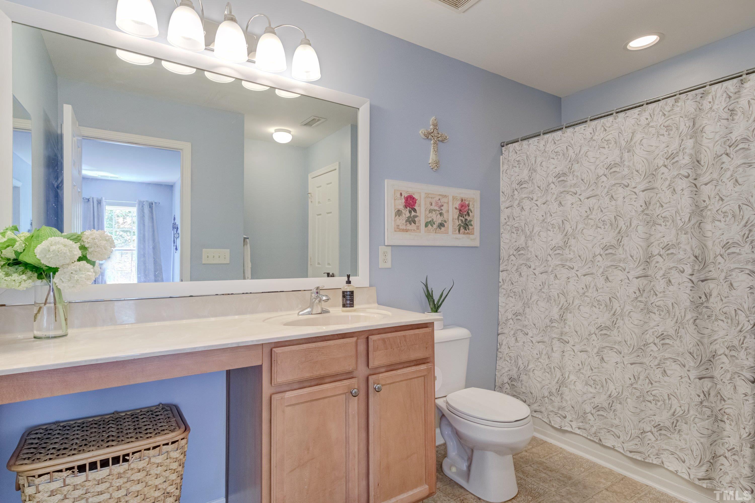 121 Ryder Cup Circle Raleigh, NC 27603 - Photo 26 of 43 a bathroom with a sink a toilet and a mirror