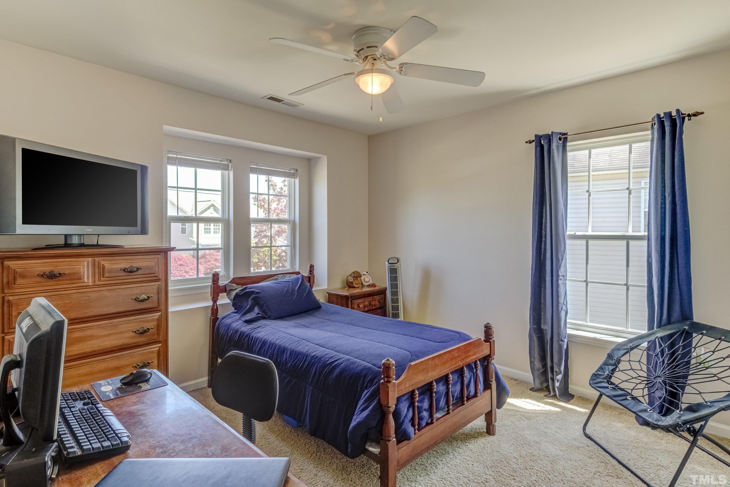 121 Ryder Cup Circle Raleigh, NC 27603 - Photo 30 of 43 a bedroom with a bed and a flat screen tv