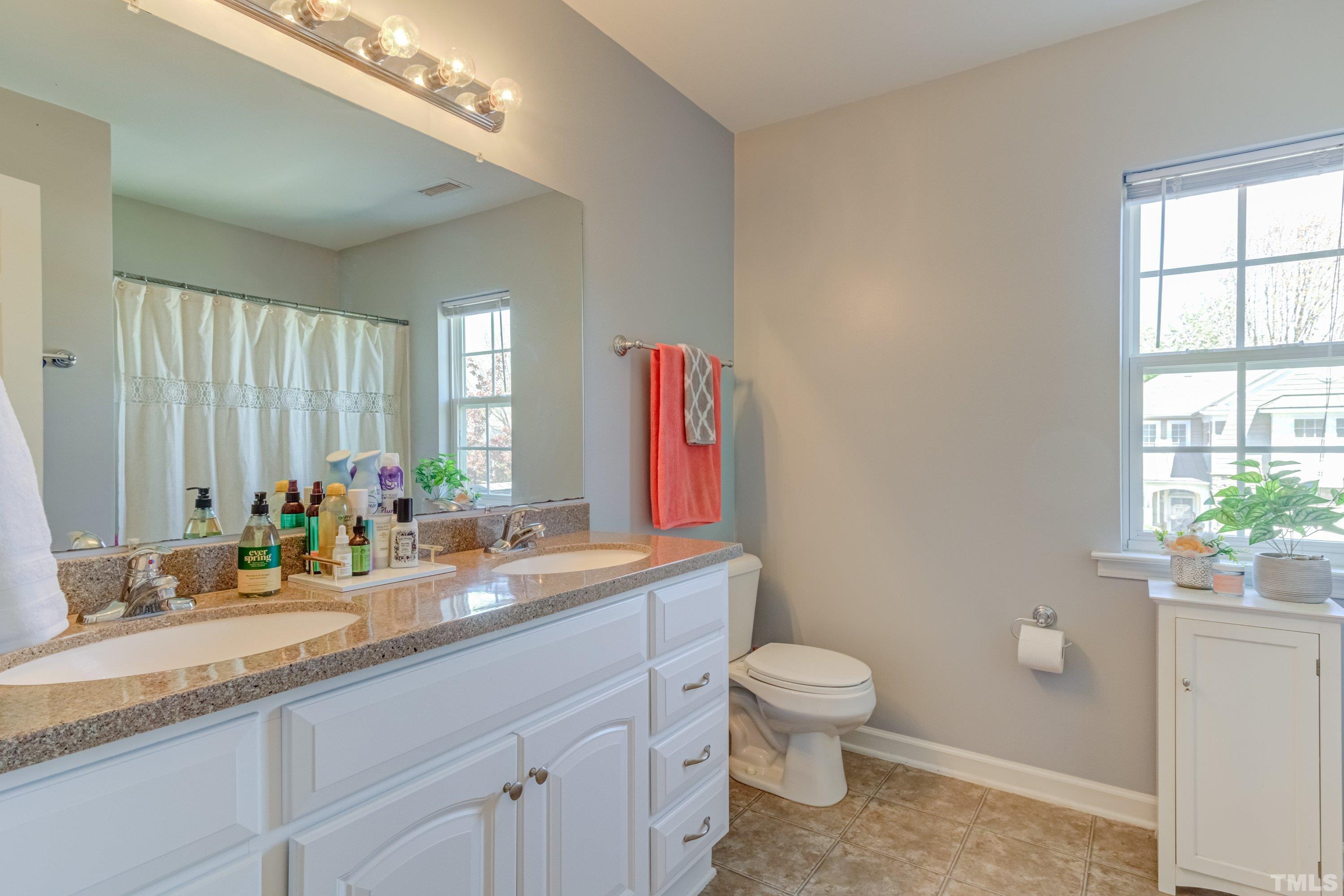 121 Ryder Cup Circle Raleigh, NC 27603 - Photo 32 of 43 a bathroom with a toilet a sink and a large mirror