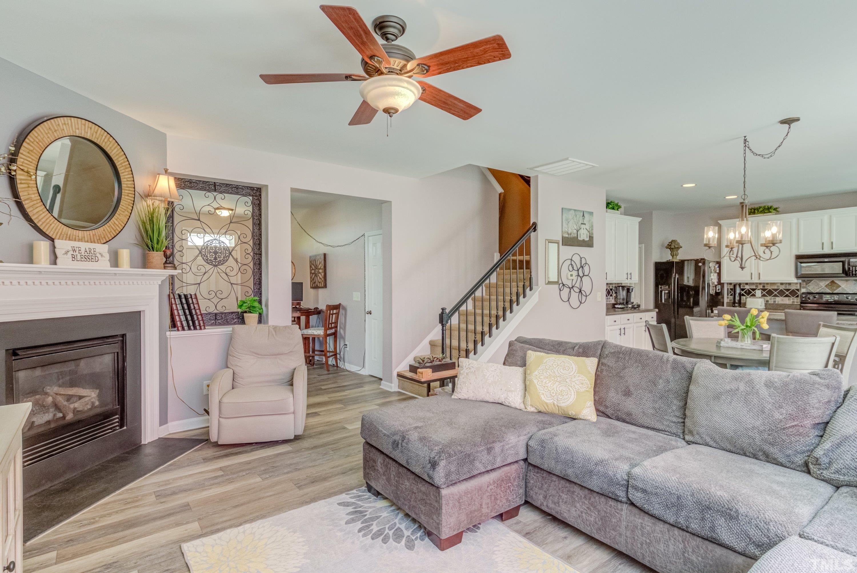 121 Ryder Cup Circle Raleigh, NC 27603 - Photo 6 of 43 a living room with furniture a fireplace and a chandelier