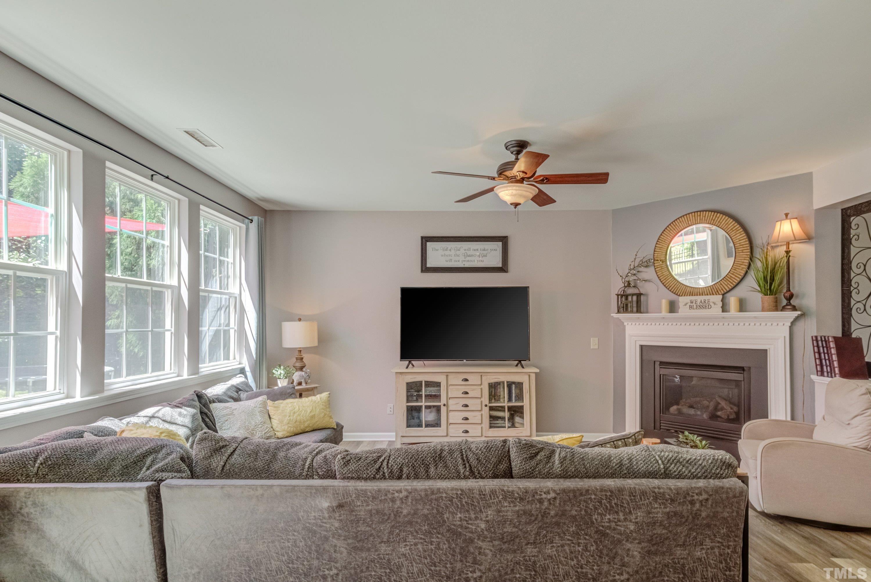 121 Ryder Cup Circle Raleigh, NC 27603 - Photo 7 of 43 a living room with furniture a fireplace and a flat screen tv