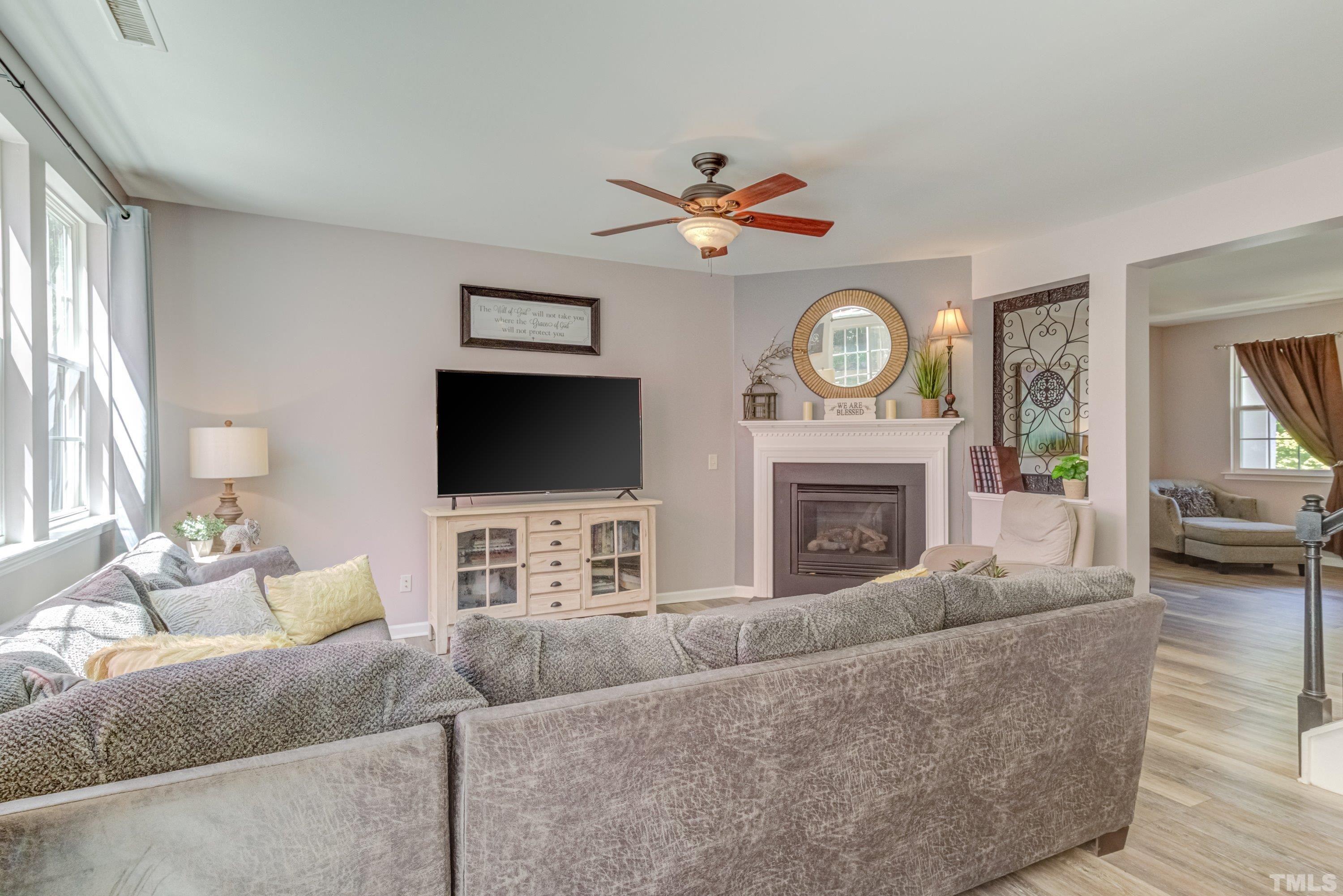 121 Ryder Cup Circle Raleigh, NC 27603 - Photo 8 of 43 a living room with furniture a fireplace and a flat screen tv