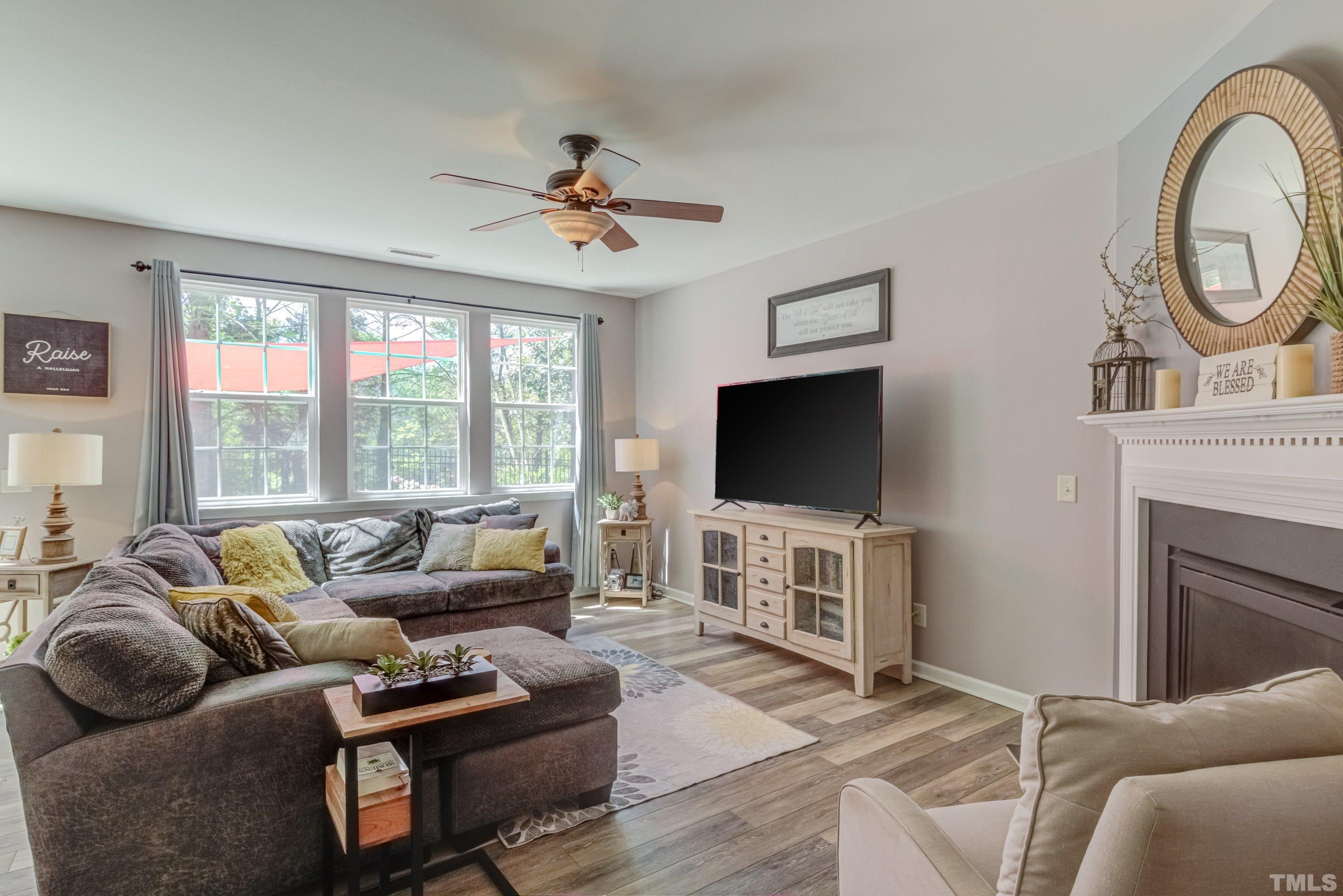 121 Ryder Cup Circle Raleigh, NC 27603 - Photo 9 of 43 a living room with furniture a flat screen tv and a large window