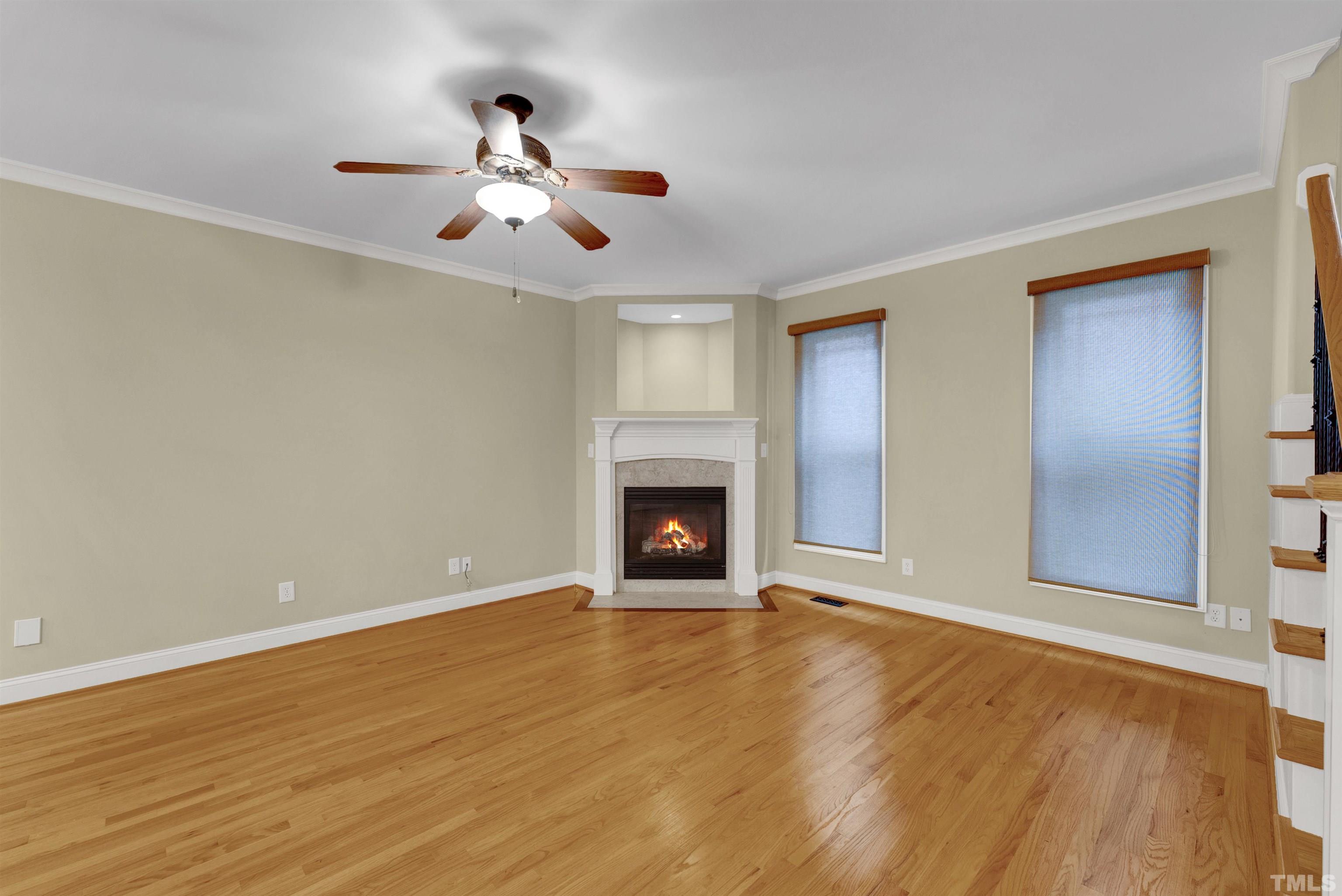 1201 Town Side Drive Apex, NC 27502 - Photo 12 of 40 a view of an empty room with wooden floor fireplace and a window