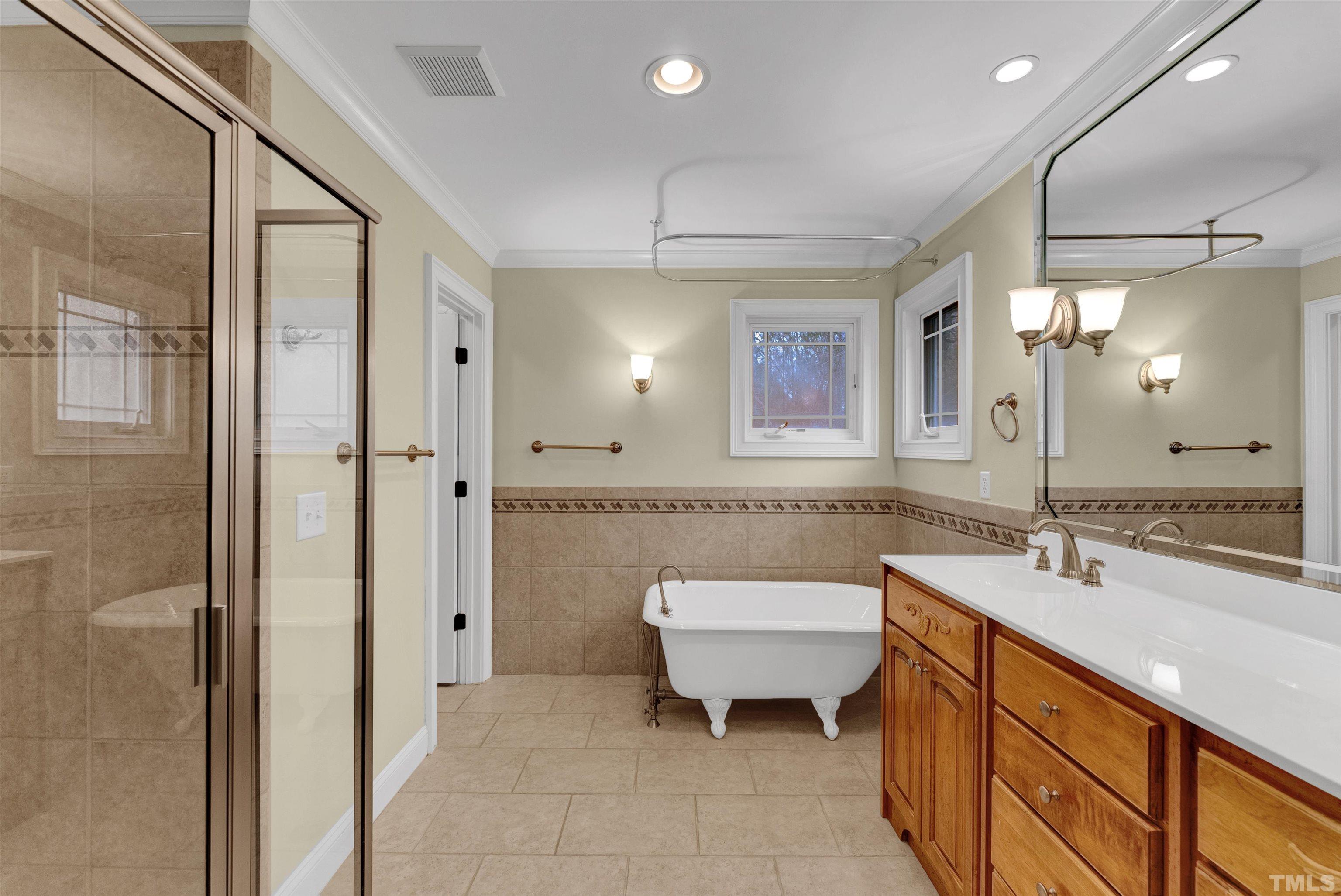 1201 Town Side Drive Apex, NC 27502 - Photo 25 of 40 a bathroom with a double vanity sink a toilet a mirror and shower