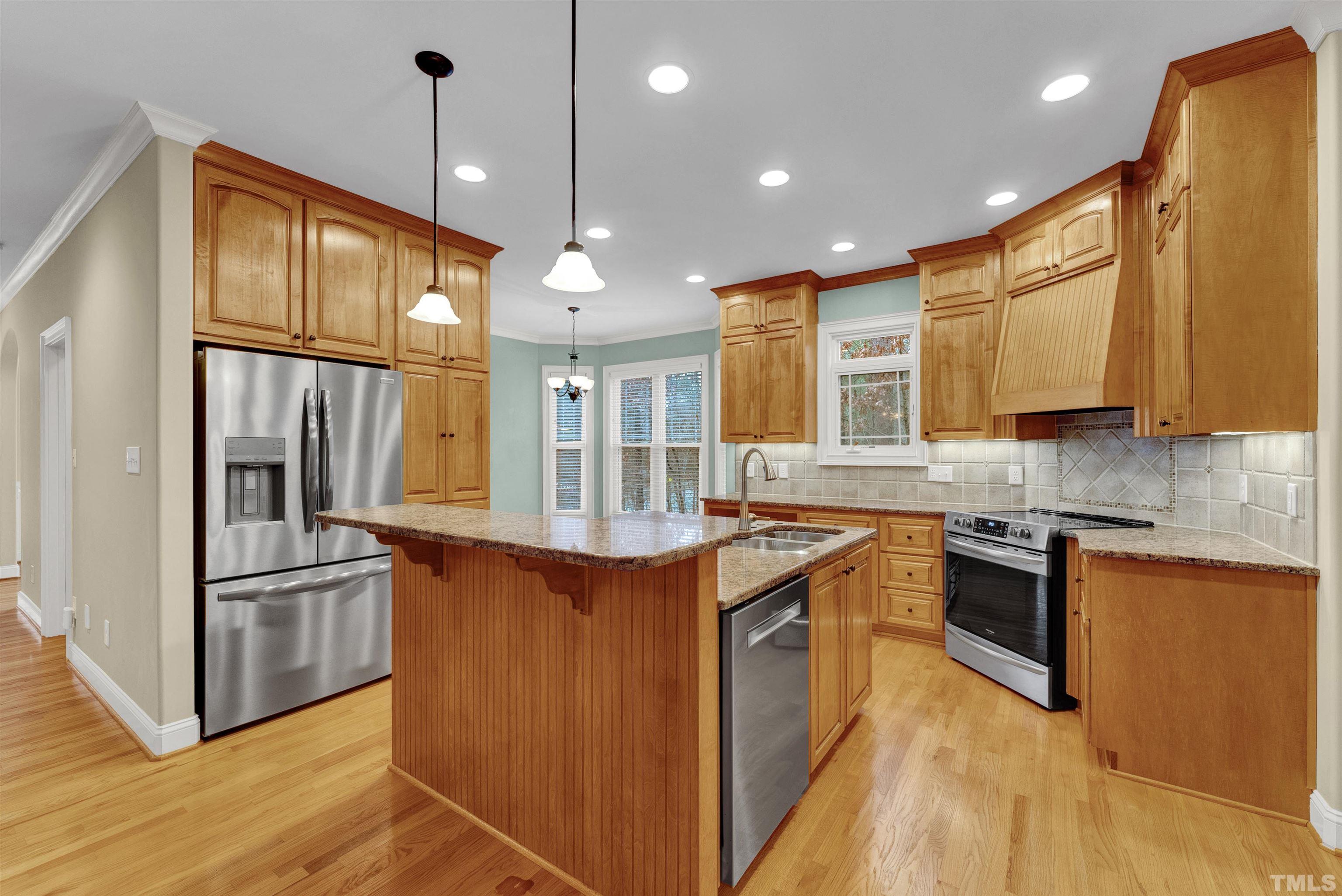 1201 Town Side Drive Apex, NC 27502 - Photo 3 of 40 a kitchen with stainless steel appliances granite countertop a sink a stove and a refrigerator