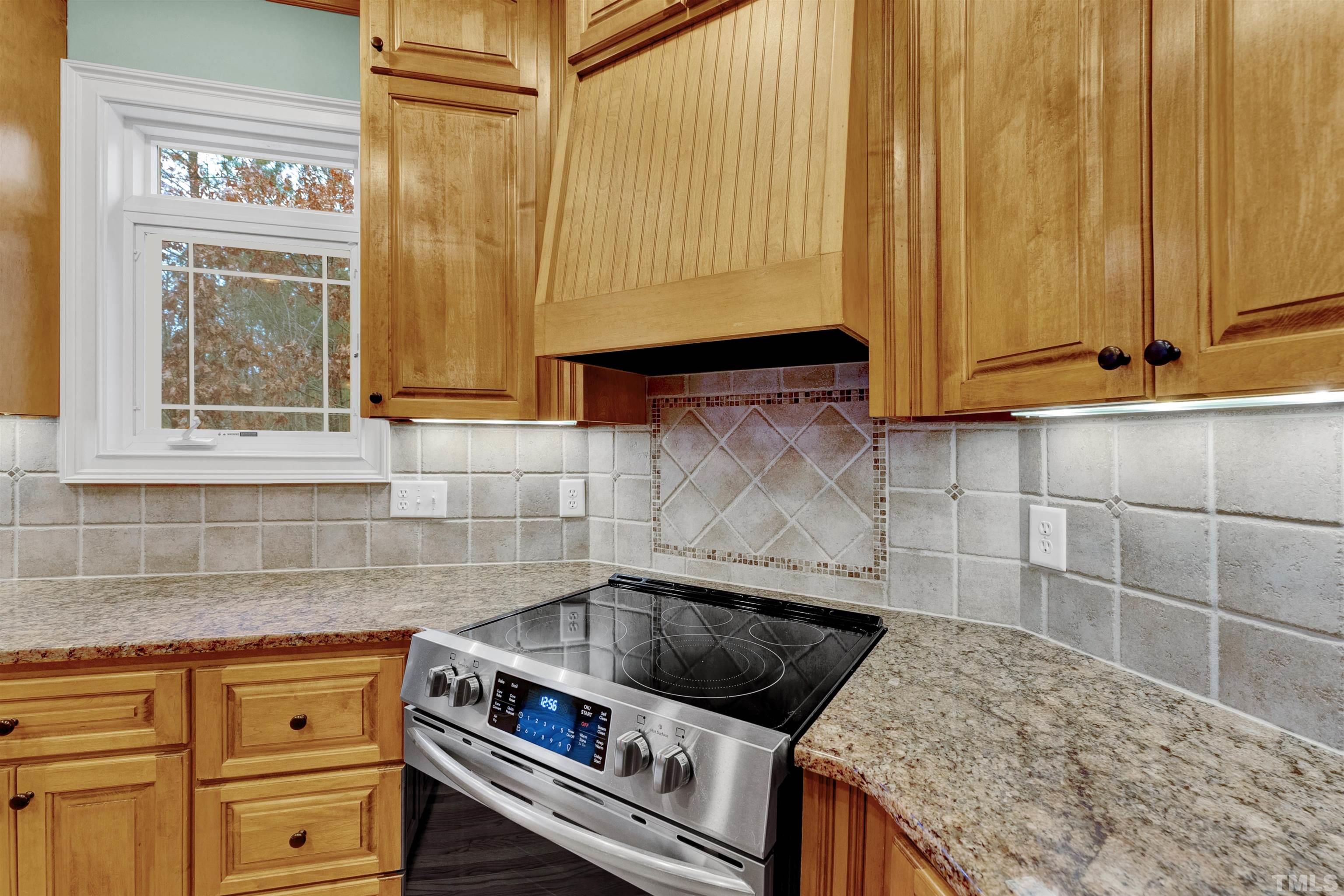1201 Town Side Drive Apex, NC 27502 - Photo 4 of 40 a kitchen with granite countertop a sink a stove and cabinets