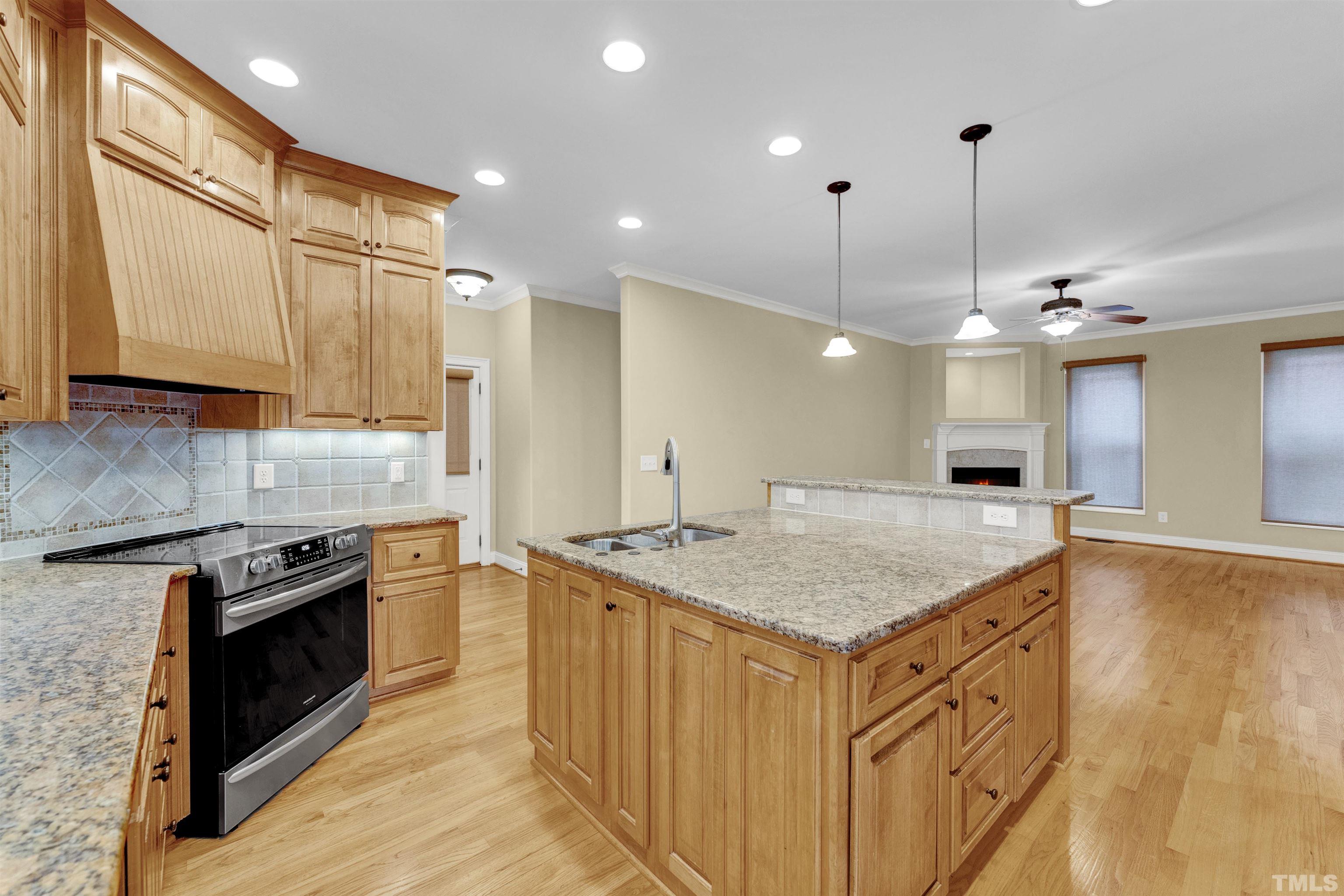 1201 Town Side Drive Apex, NC 27502 - Photo 8 of 40 a kitchen with stainless steel appliances granite countertop a sink a stove and a wooden floors