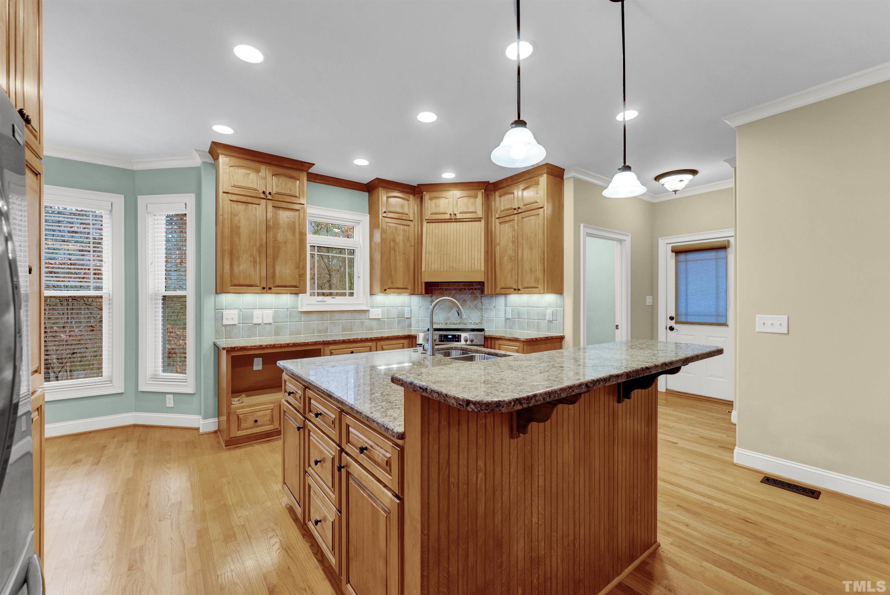 1201 Town Side Drive Apex, NC 27502 - Photo 9 of 40 a kitchen with stainless steel appliances granite countertop a sink a stove and a wooden floors