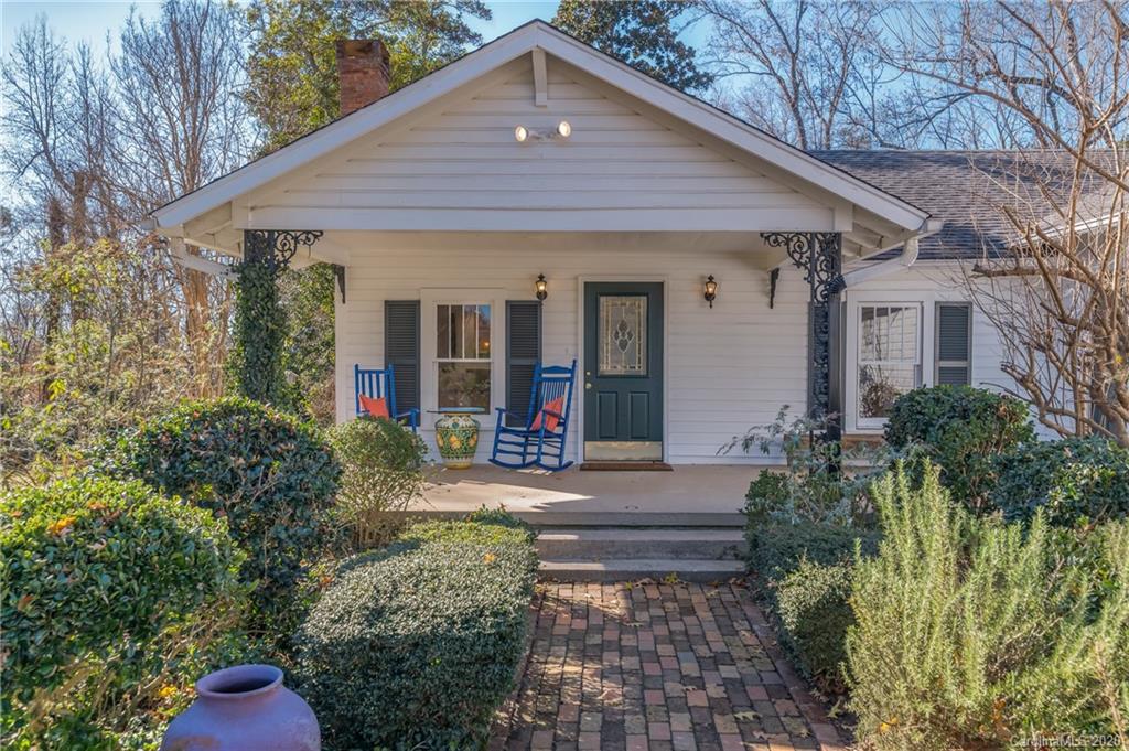 5975 Hunting Country Road Tryon, NC 28782 - Photo 1 of 47 a front view of a house with small yard and potted plants