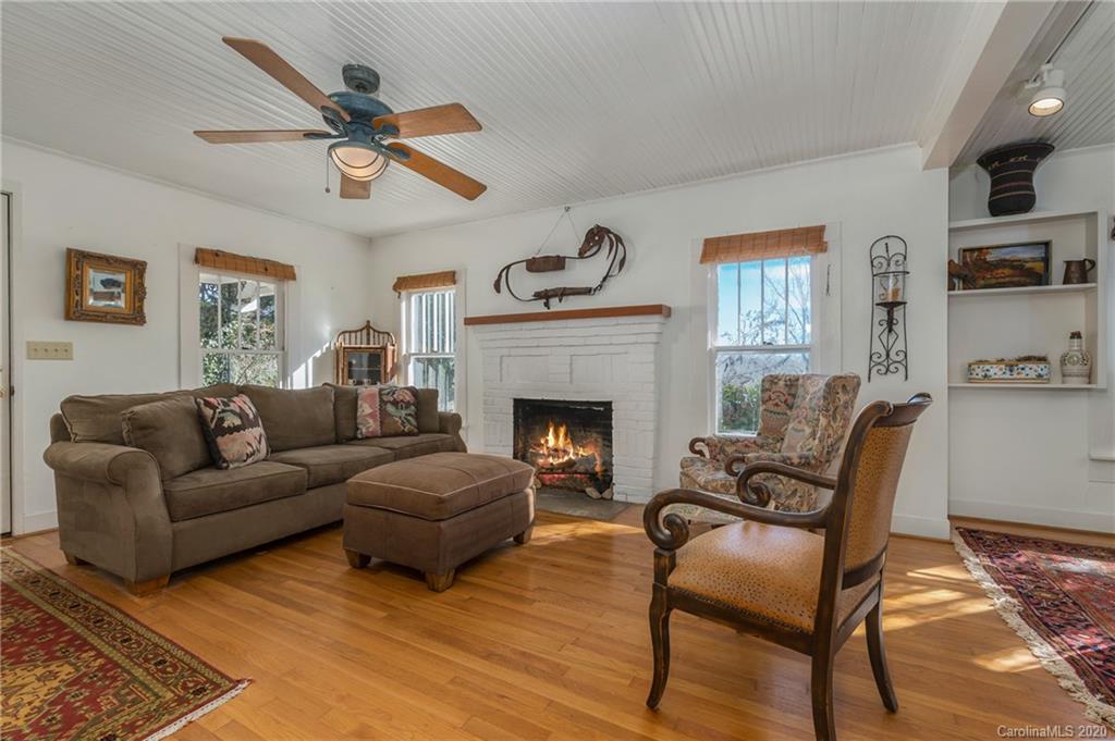 5975 Hunting Country Road Tryon, NC 28782 - Photo 4 of 47 a living room with furniture a clock and a fireplace