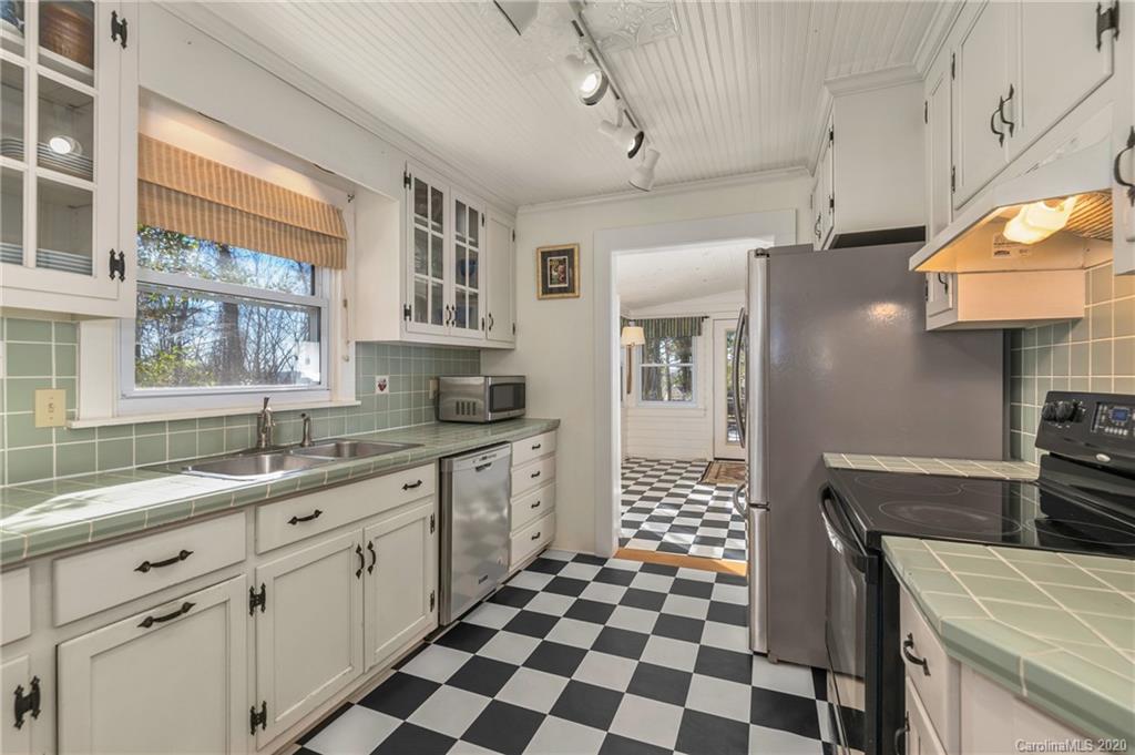 5975 Hunting Country Road Tryon, NC 28782 - Photo 33 of 47 a kitchen with a sink a stove a refrigerator and cabinets