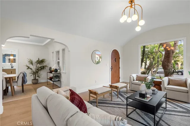 a living room with furniture chandelier and a large window