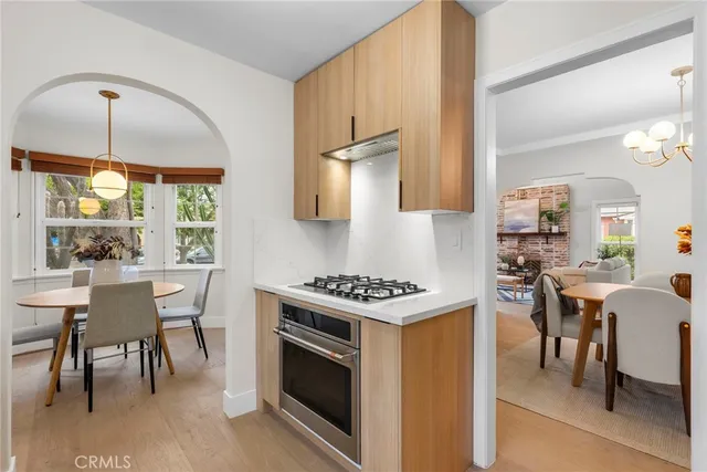 a kitchen with a stove a sink and chairs