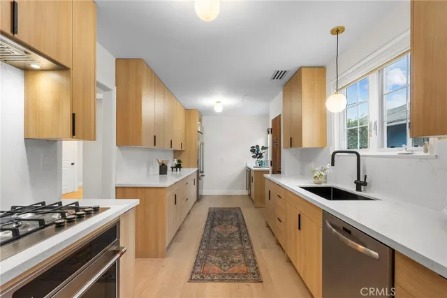 a kitchen with stainless steel appliances a sink stove and cabinets