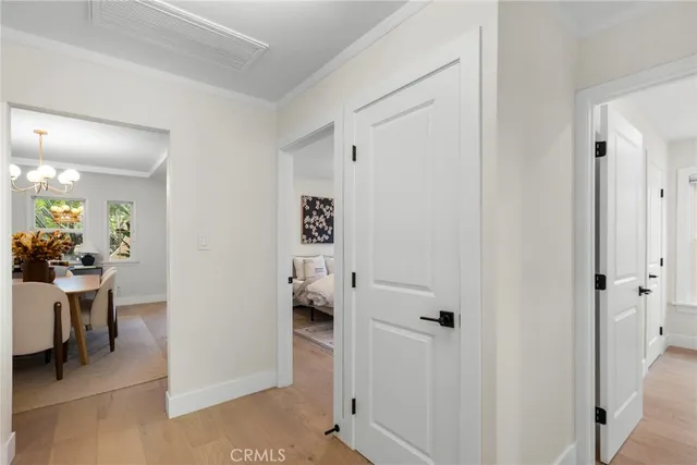 a view of a hallway with dining room and wooden floor
