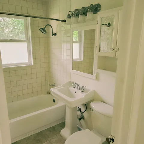 a bathroom with a sink mirror toilet and bathtub