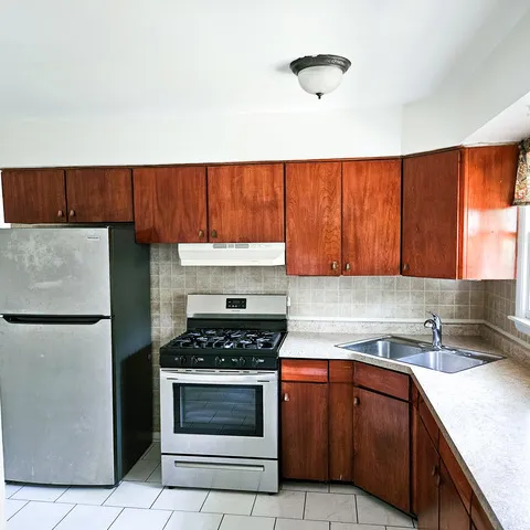 a kitchen with granite countertop a sink a stove and cabinets