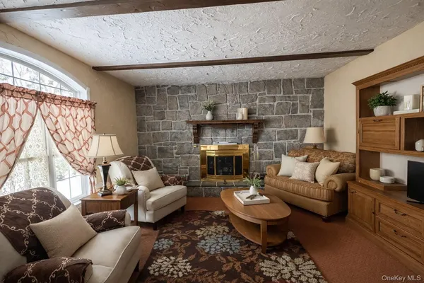 a living room with furniture a fireplace and a large window