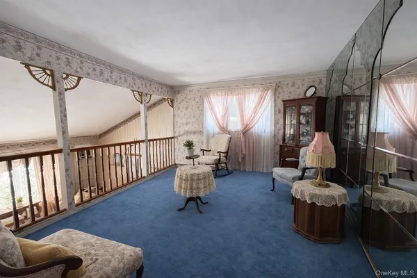 a living room with furniture stairs and a window