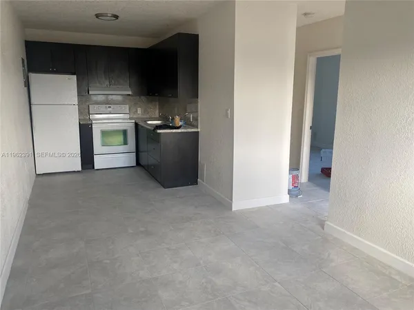a view of a kitchen with a sink an oven and cabinets