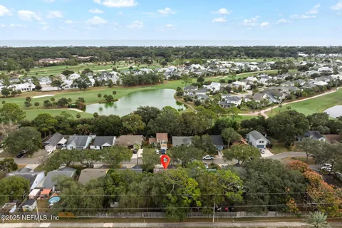 an aerial view of residential houses with outdoor space and river