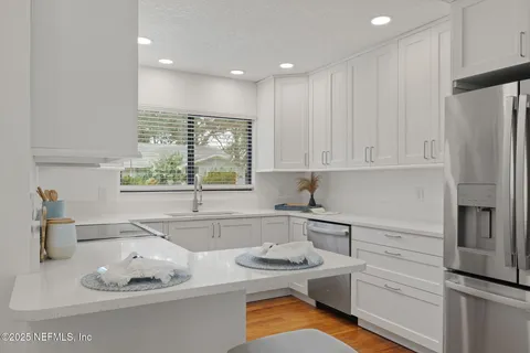 a kitchen with stainless steel appliances granite countertop a sink and a refrigerator