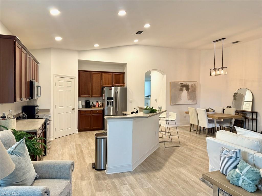 1252 Rialto Way, Unit 202 Naples, FL 34114 - Photo 26 of 26 a living room with stainless steel appliances kitchen island granite countertop a couch and a view of kitchen