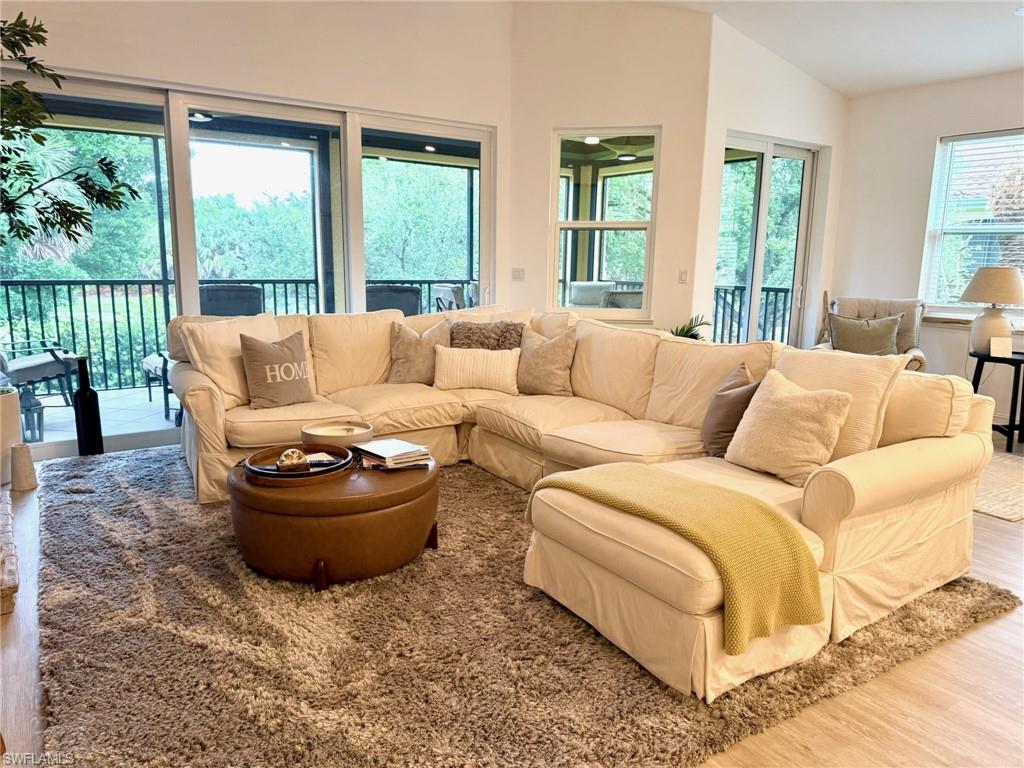 1252 Rialto Way, Unit 202 Naples, FL 34114 - Photo 12 of 26 a living room with furniture and large windows