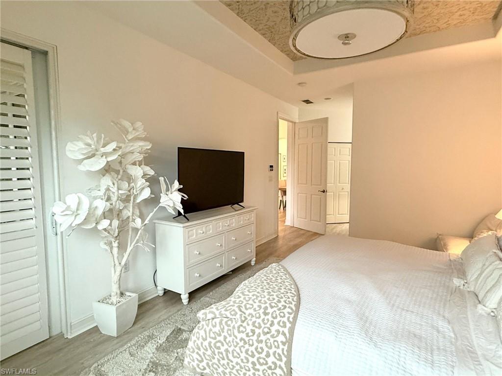 1252 Rialto Way, Unit 202 Naples, FL 34114 - Photo 18 of 26 a bedroom with a bed and a flat screen tv