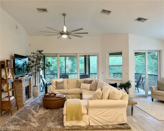 a living room with furniture a flat screen tv and a large window