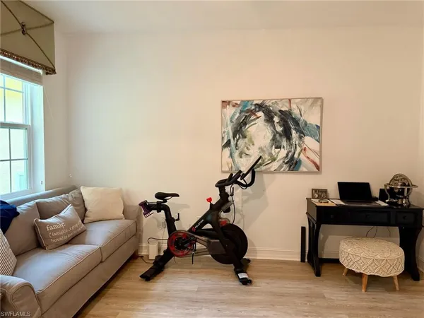 a view of a hallway with wooden floor and windows