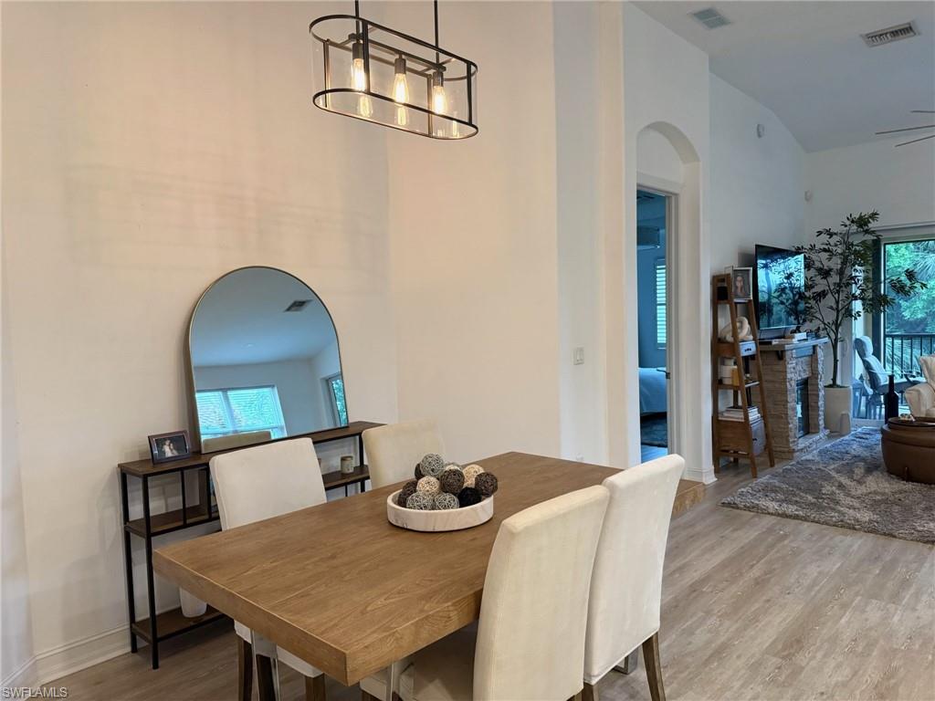 1252 Rialto Way, Unit 202 Naples, FL 34114 - Photo 3 of 26 a view of a dining room with furniture and wooden floor