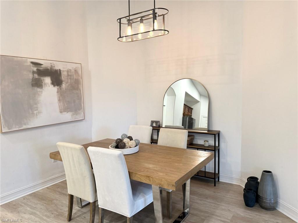 1252 Rialto Way, Unit 202 Naples, FL 34114 - Photo 8 of 26 a view of a dining room with furniture and wooden floor