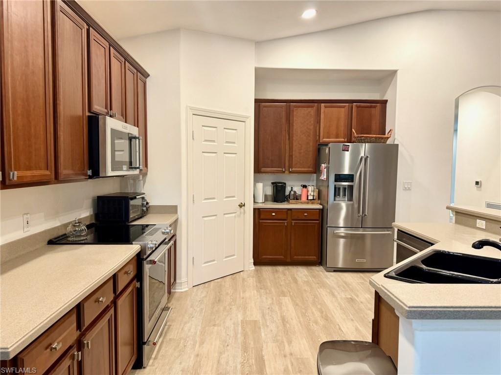 1252 Rialto Way, Unit 202 Naples, FL 34114 - Photo 9 of 26 a kitchen with a sink a refrigerator and a stove top oven