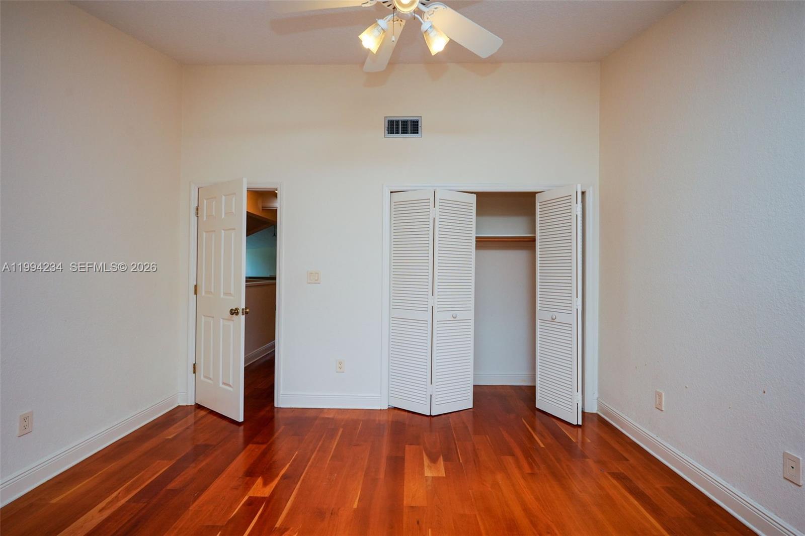 113 Durham Place Longwood, FL 32779 - Photo 52 of 56 an empty room with wooden floor and way to kitchen