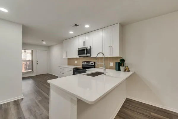 a kitchen with a sink a counter top space cabinets and stainless steel appliances