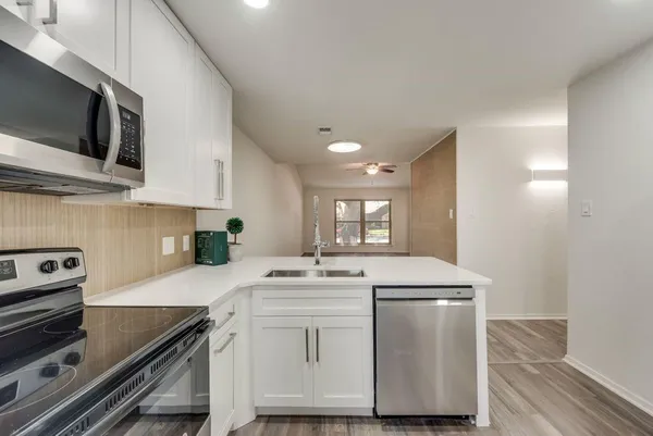 a kitchen with a sink a stove and cabinets