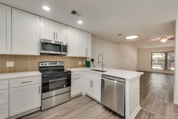 a kitchen with a stove a sink and a microwave