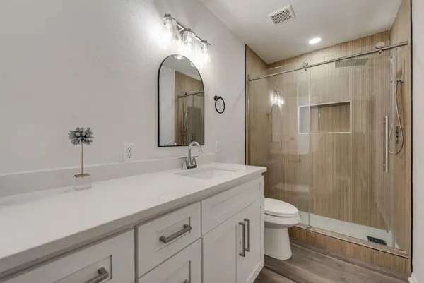 a bathroom with a double vanity sink toilet and shower