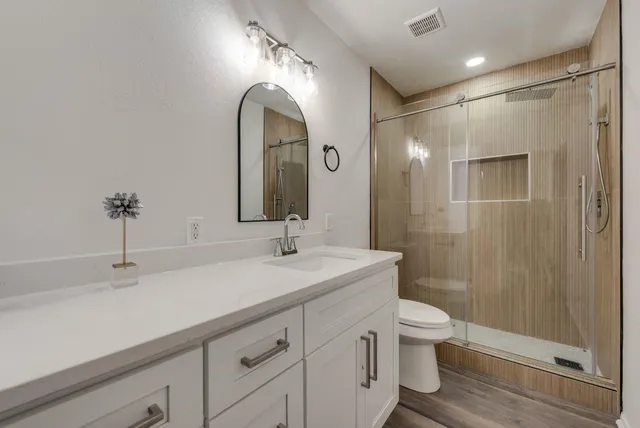 a bathroom with a double vanity sink toilet and shower