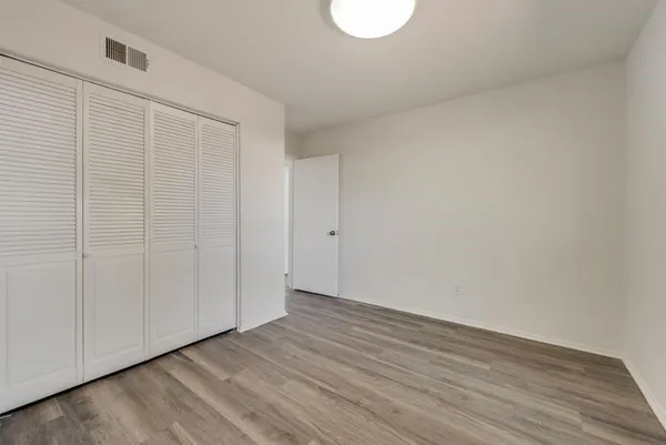 a view of an empty room with wooden floor
