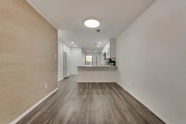 wooden floor in an empty room with a kitchen